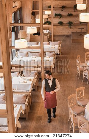 Waiter Going Between Empty Tables