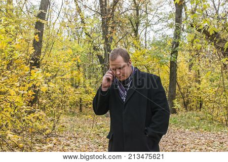 Handsome Young Man With A Smartphone On The Street Talking In The Park.