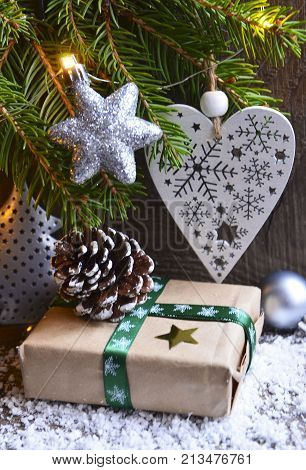 Christmas decoration with fir tree,fift, garland lights,white christmas heart and pine cone on old wooden background.Winter holidays,Merry Christmas,Happy New Year concept.Copy space.Selective focus.