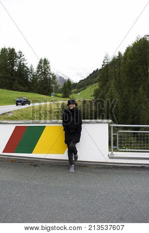 Asian Thai Woman Travel And Posing For Take Photo With Alps Mountain At Petrol Station