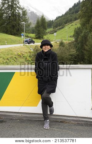 Asian Thai Woman Travel And Posing For Take Photo With Alps Mountain At Petrol Station
