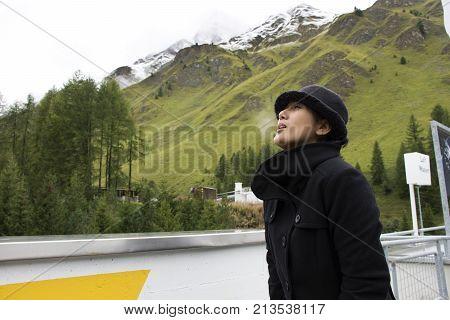 Asian Thai Woman Travel And Posing For Take Photo With Alps Mountain At Petrol Station