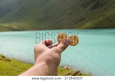 Hand with 2 funny crackers near lake