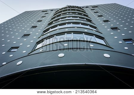 ROTTERDAM HOLLAND- AUGUST 23 2017; Low angle view modern unusual exterior architectural tower black extrior with white dots towers skyward from street below