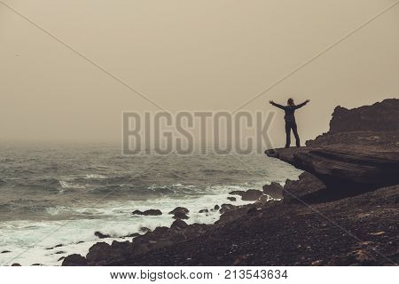 Woman standing on a cliff.