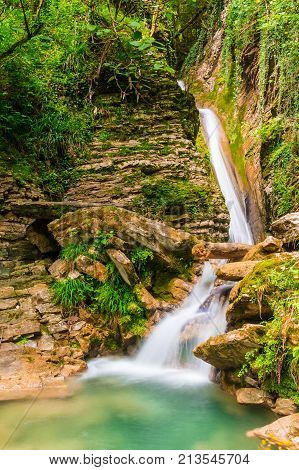 Waterfall and small lake in the ravine Chudo-Krasotka in summer day Sochi Russia