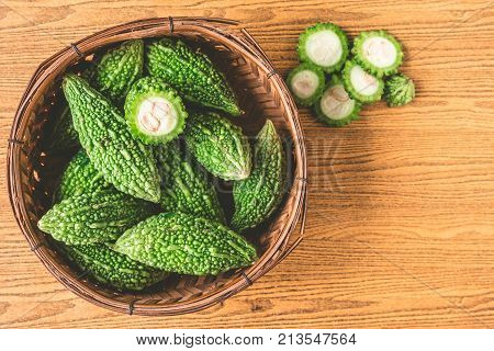 Bitter melon or bitter gourd in wooden basket. Free space for taxt