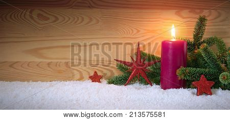 Avent candle and christmas decoration isolated on wood background. Christmas background with snow, candle and red stars.