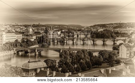 Historic bridges of Prague at the golden hour photographed from Letna park. Vintage black and white processed.