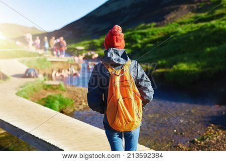 back view of woman traveler on a walk in the Valley of the river of Hveragerdi Iceland. Hiking Tour of Reykjadalur Hot Springs