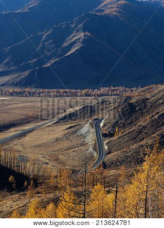 A winding mountain road. Climb to the pass. Autumn time of the year.