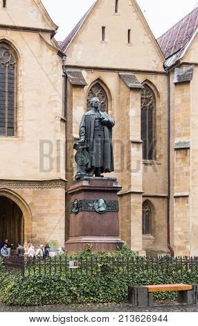 Sibiu Romania October 07 2017 : The statue of Loi Georg Daniel Teutsch in front of Lutheran Cathedral of Saint Mary in a rainy day. Sibiu city in Romania