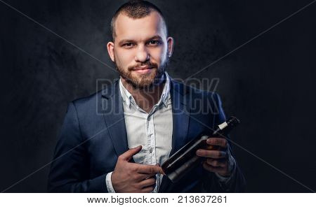 A trendy bearded male dressed in an elegant suit presenting craft beer.