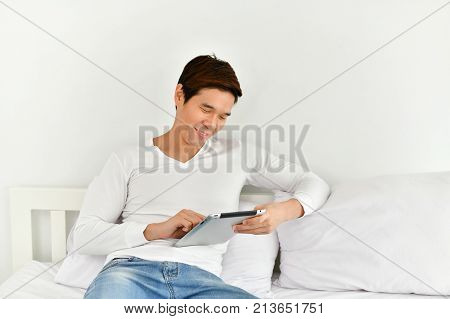 Men are playing mobile in the bedroom.