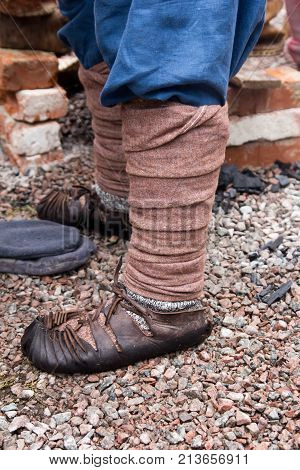 Old Russian sandals on his feet . In the park in nature