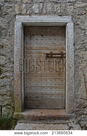 An old wooden door in a derelict building the historic hill village of Erto in Friuli Venezia Giulia north east Italy