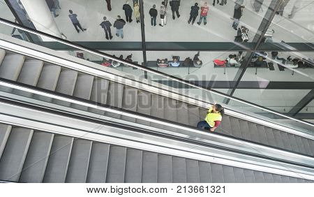 ZAGREB AIRPORT - 24 APRIL 2017: Aerial view of passengers waiting in hall, escalators passing.