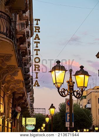 Taranto Italy - August 11 2017. Trattoria signboard in a street of Taranto at nightfall. Taranto Puglia Italy.