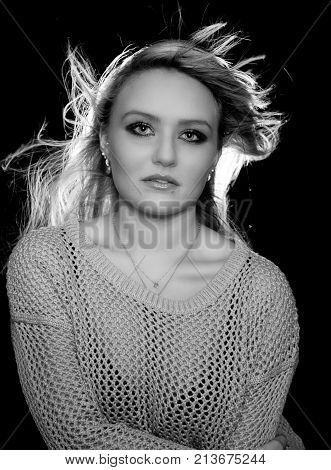 Young blonde woman with flyaway hair is posing