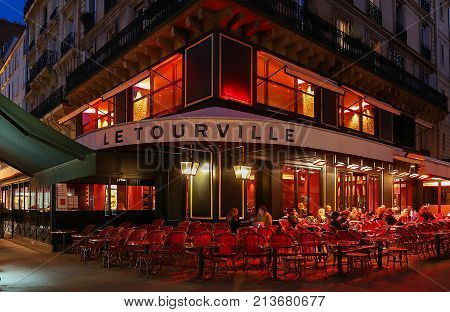 PARIS, FRANCE - OCTOBER 30, 2017: Le Tourville night view, a typical French cafe located near the Eiffel tower in Paris, France.