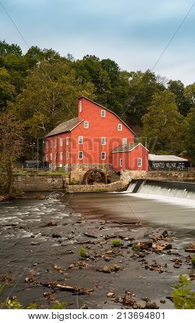 The historic Red Mill in Clinton NJ with people fishing in the river. The village also decorated for halloween as photo taken in Mid October