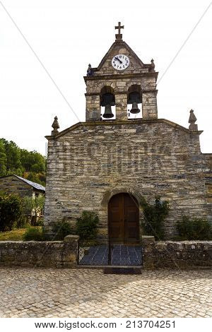 The parish church of St john the Baptist built in the sixteenth century has a pair of bells a clock and a cross in Rio de Onor Braganca Portugal