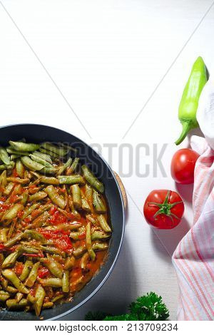 Cooked green bean with tomato sauce on white background