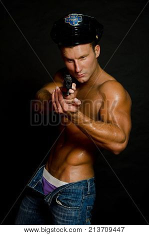 Sexy cop. Handsome man shirtless and with a gun.