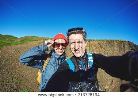couple hikers travelers on a walk in the Valley of the river of Hveragerdi Iceland. Hiking Tour of Reykjadalur Hot Springs. woman and man making selfie in Iceland