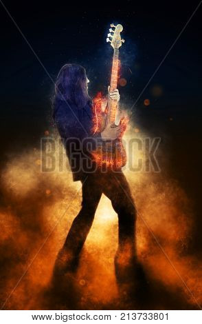 Man playing electric guitar on fire background