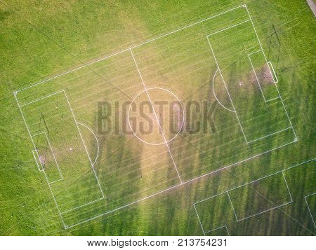 Football (soccer) pitch, aerial view. Aerial drone photo looking down vertically onto an empty football (soccer) pitch with shadows cast by the low sun.