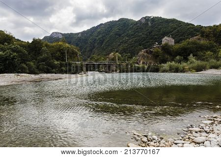 a bridge to a church across a mountain river