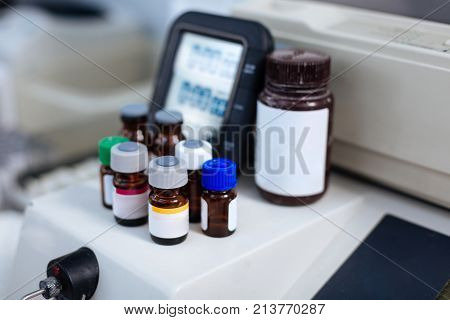 Never mix up. Several different size vials gathered together with digital panel located on the background waiting to heal you