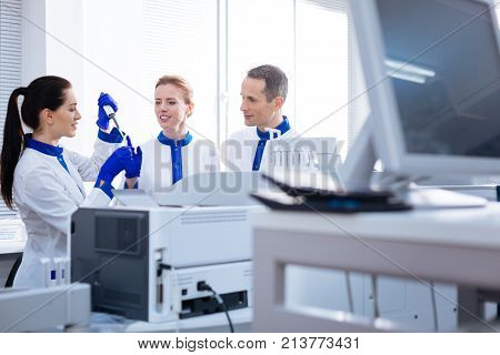 First step. Knowledgeable laboratorians monitoring the unexperienced pleasant young intern conducting analyses  when looking at her