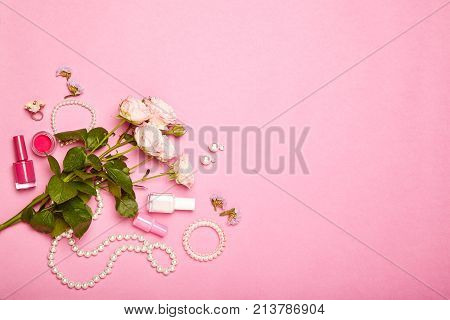 Fashionable Women's Cosmetics and Accessories. Falt Lay. Nail Polish and blush. Jewelry and Rings. A bouquet of flowers. Pink roses