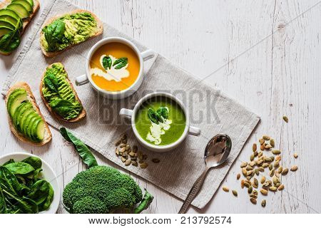 Vegetarian healthy food. Soup and vegan sandwiches. Different sandwiches with avocado. Brunch on white wooden background.