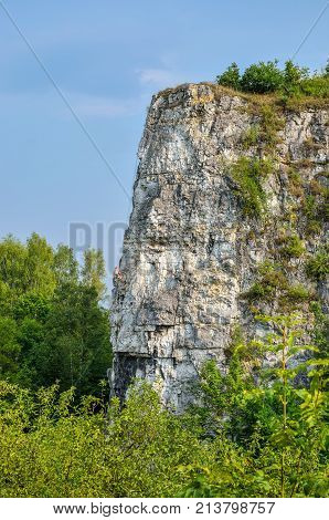 Beautiful summer landscape. Climber on the rocks of Twardowski at the lagoon of Zakrzowek in Krakow Poland.