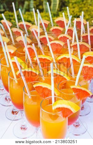 Orange juice cocktail in a flute glasses and slice of fresh orange with draw on white tableclosed picture.