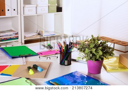 Office table with blank notepad and laptop .