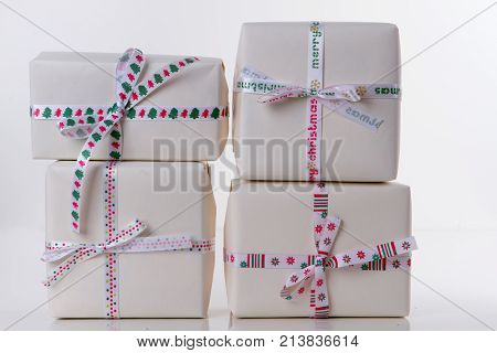 Four gift boxes in white paper with colorfull ribbons on the white background