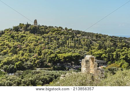 view from an arcade of the theater odeon in the acropolis to the monument to philopappos in the hill of the same name athens.