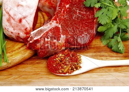 raw meat : fresh beef pork big rib and fillet with garlic and green stuff on wood isolated over white background
