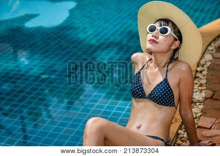 Women wearing bikini or swimware suits at swimming pool at the resort of Pattaya in Thailand.