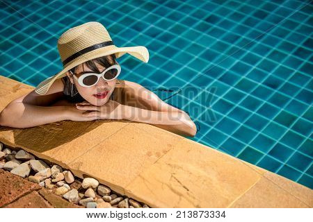 Women wearing bikini or swimware suits at swimming pool at the resort of Pattaya in Thailand.