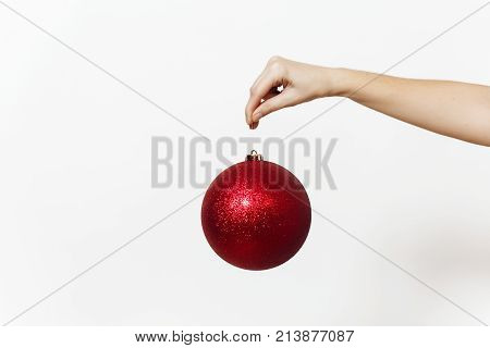 Christmas Concept With Female Hand And Big Red Round Shiny Ball - Christmas Tree Toy Isolated On Whi