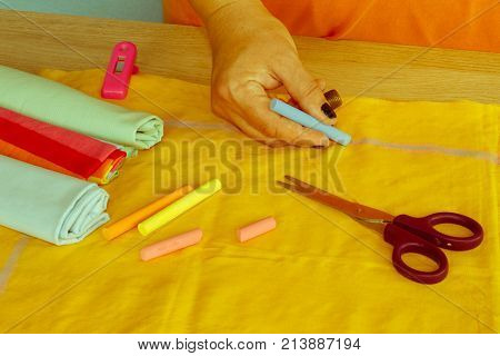 closeup of woman hands sewing yellow cloth outdoors. Woman's Hand Sewing Quilt