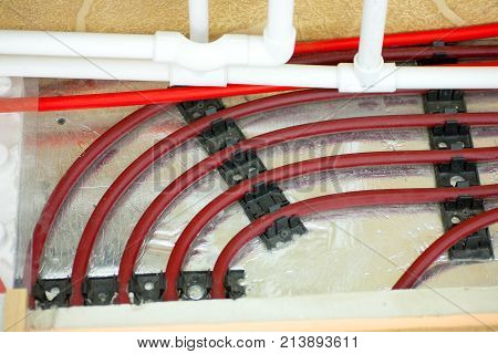 laying of pipes of a warm floor under a laminate of a parquet and a tile Floor heating pipe. Installation of engineering systems in a building.