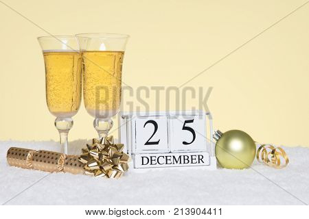 Christmas party still life with two glasses of Champagne and a date block showing 25th December. Copy space on the background for your own message such as invitation.