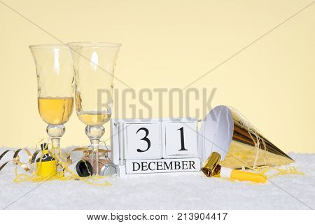 New Year party still life with two empty glasses of Champagne and a date block showing 31st December with streamers. Copy space on the background for your own message such as invitation.