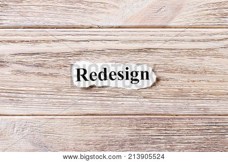REDESIGN of the word on paper. concept. Words of REDESIGN on a wooden background.